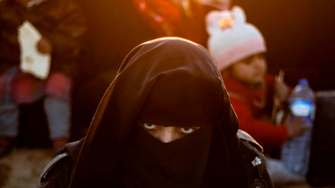 A woman looks on as she waits to be searched by members of the Kurdish-led Syrian Democratic Forces (SDF) after leaving the Islamic State (IS) group's last holdout of Baghouz, in the eastern Syria, March 1, 2019. (DELIL SOULEIMAN/AFP/Getty Images)