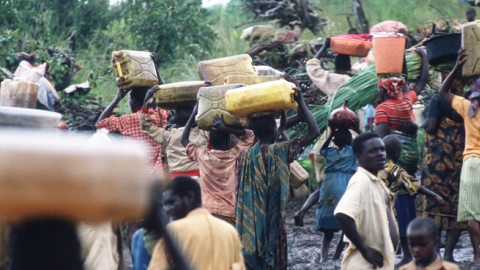 A crowd of refugees carry their belongings May 3, 1994 at the border of Rwanda and Tanzania. Hutu refugees have fled to Tanzania border across the Akagara River in order to escape reprisals by Tutsi rebels. (Scott Peterson/Liaison)