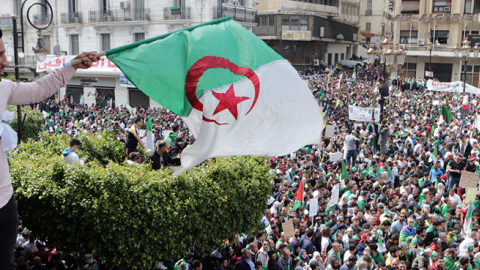An Algerian protester waves a flag during an anti-government demonstration to demand an overhaul of the political system after long-serving president Abdelaziz Bouteflika resigned. (picture alliance/Getty Images)
