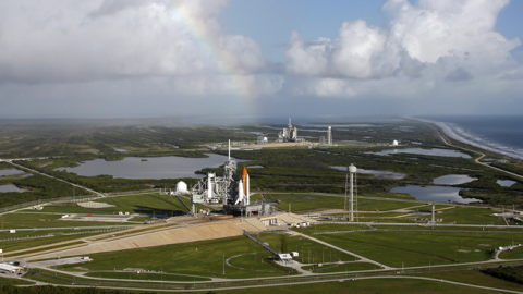 With a rainbow serving as a backdrop in the sky, space shuttle Atlantis (foreground) sits on Launch Pad A and Endeavour on Launch Pad B at NASA's Kennedy Space Center in Florida. (Stocktrek Images)