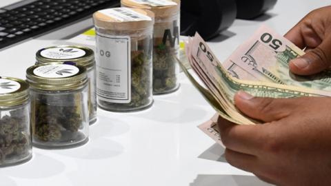  A customer pays for cannabis products at Essence Vegas Cannabis Dispensary after the start of recreational marijuana sales began on July 1, 2017 in Las Vegas, Nevada. (Getty Images)