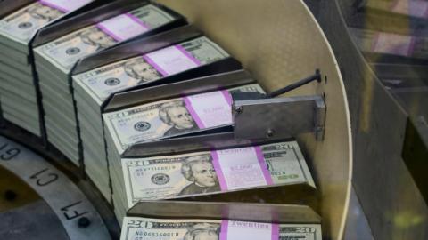 Packs of freshly printed 20 USD notes are processed for bundling and packaging at the US Treasury's Bureau of Engraving and Printing in Washington, DC July 20, 2018. (EVA HAMBACH/Getty Images)