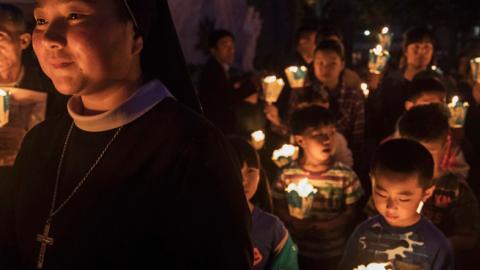 Chinese Catholics hold candles at a mass on Holy Saturday during Easter celebrations at the government sanctioned West Beijing Catholic Church on April 15, 2017 in Beijing, China. (Kevin Frayer/Getty Images)