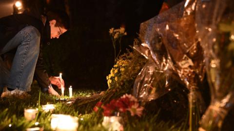 A woman kneels to place a candle outside the Tree of Life Synagogue after a shooting there left 11 people dead in the Squirrel Hill neighborhood of Pittsburgh on October 27, 2018. (Getty Images)