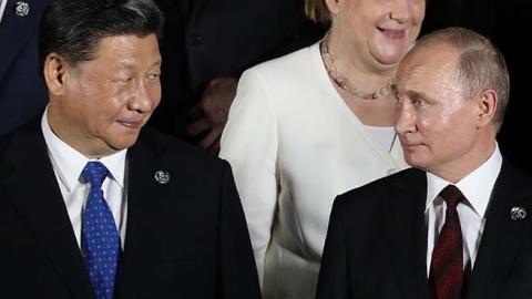 Russian President Vladimir Putin (front R) and Chinese President Xi Jinping as they arrive to pose for a group photo before a cultural event at the Osaka Geihinkan in Osaka Castle Park during the G20 Summit in Osaka. (Getty Images)