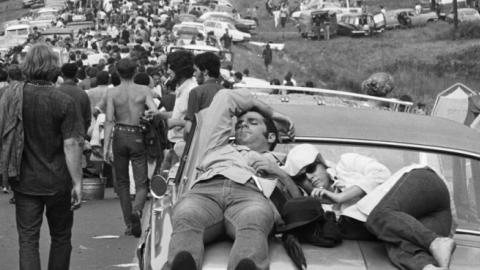 On foot, in cars, atop cars, young people leave the Woodstock Music Festival. (Getty Images)