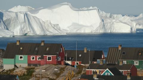 Icebergs floating at the mouth of the Ilulissat Icefjord loom behind the town center on July 30, 2019 in Ilulissat, Greenland. (Sean Gallup/Getty Images)