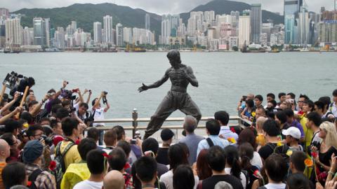 Fans gather around a statue of Bruce Lee to mark the 40th anniversary of his death, on the Avenue of the Stars in Hong Kong on July 20, 2013. Lee helped put Hong Kong on the movie world map. (ANTHONY WALLACE/Getty Images)