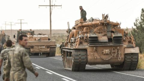 Turkish soldiers secure a road before army tanks start moving toward the Syrian border in Ceylanpinar, Turkey, on Oct. 18. (BURAK KARA/GETTY IMAGES)