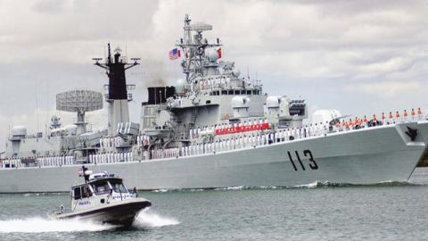 The Chinese Navy destroyer Qingdao (DDG 113) transit through the Pearl Harbor channel while being escorted by a harbor patrol boat as it arrives for a routine port visit. (U.S. Navy photo, released)