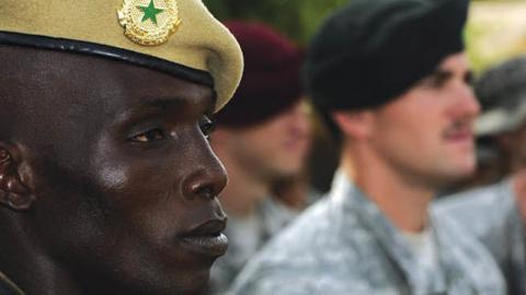 A Malian solider stands with U.S. military personnel.