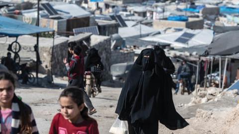 Displaced Syrians walk on the road at village of Atmeh which hosts nearly 2 million displaced Syrians on February 20, 2020 in Idlib, Syria.