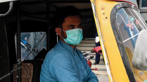 An auto-rickshaw driver wears a protective facemask as a prevention measure against the  COVID-19 coronavirus as he wait for passengers along a street in Quetta on February 27, 2020 as Pakistan has detected its first two cases of novel coronavirus. - Paki