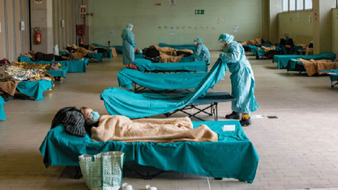 Medical personnel care for patients in an emergency temporary room, set up to ease pressure on the healthcare system, at a hospital in Brescia, Italy, on Friday, March 13th, 2020. 