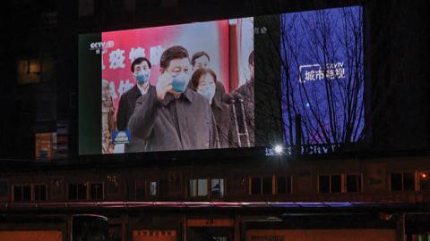  A large screen in the street shows Chinese president Xi Jinping wearing a protective mask during his visit to Wuhan earlier in the day, the epicentre of the coronavirus, on CCTV's evening newscast on March 10, 2020 in Beijing, China. 