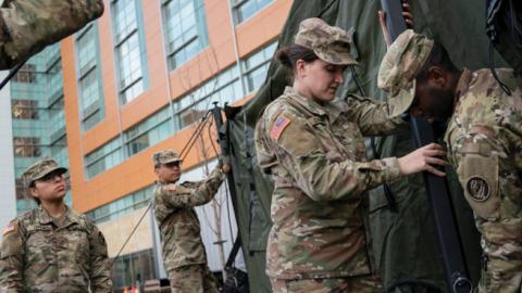 Members of the Maryland Army National Guard work to set up a triage tent in the parking lot outside of the emergency room at Adventist HealthCare White Oak Medical Center on March 19, 2020 in Silver Spring, Maryland. (Drew Angerer/Getty Images)