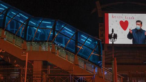 A large monitor shows an image of Chinese president Xi Jinping wearing a mask in the nearly empty Beijing Station on March 13, 2020 in Beijing, China.