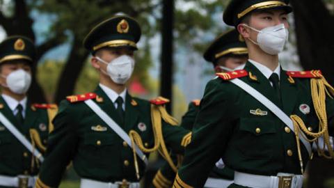 Chinese soldiers wearing protective masks march at the People's Square on April 04, 2020 in Shanghai, China