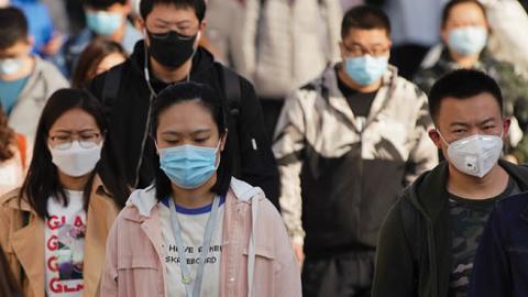 Commuters wear protective masks as they exit a train at a subway station during Monday rush hour on April 13, 2020 in Beijing, China