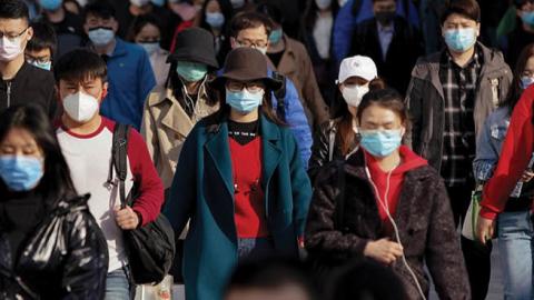 Commuters wear protective masks as they exit a train at a subway station during Monday rush hour on April 13, 2020 in Beijing, China
