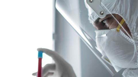 A researcher holds a tube with the coronavirus