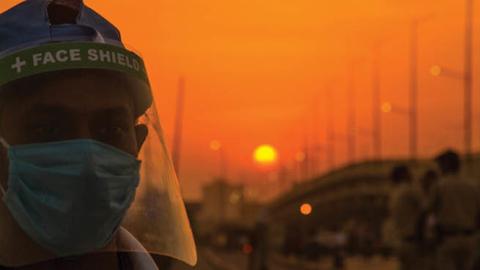 An Indian volunteer wearing a protective mask and face shield stands guard on a road, as India remains under an extended lockdown due to COVID-19 on May 6, 2020 in New Delhi, India.