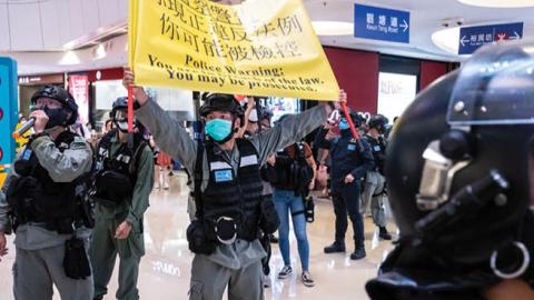 Riot police hold up a warning flag during a demonstration in a mall on July 6, 2020 in Hong Kong, China.