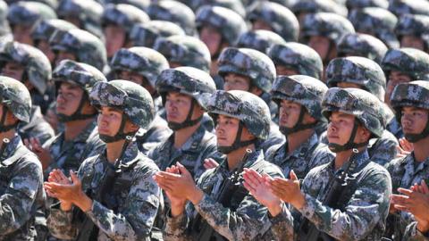 Chinese soldiers applaud during a military parade at the Zhurihe training base in China's northern Inner Mongolia region on July 30, 2017