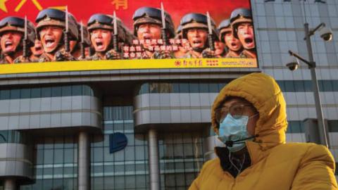 A bicyclist rides past government propaganda in Beijing, April 20.