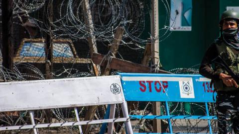 An Indian paramilitary trooper stands guard in front of his bunker in the deserted city square during a curfew like restrictions, a year after India revoked the special status of Jammu and Kashmir, in the city center on August 05, 2020