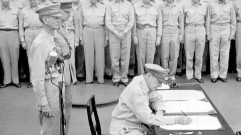 English: General Douglas MacArthur signs as Supreme Allied Commander during formal surrender ceremonies on the USS MISSOURI in Tokyo Bay.