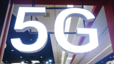 Attendees and workers chat beneath a '5G' logo at the Quectel booth at CES 2020 at the Las Vegas Convention Center on January 8, 2020 in Las Vegas, Nevada.