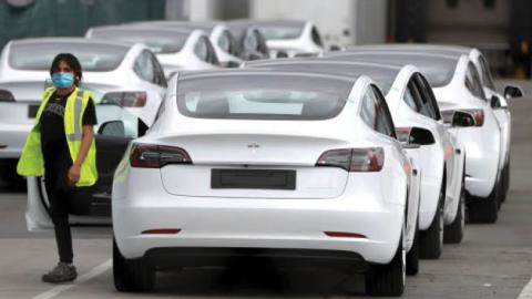 A worker exits a Tesla Model 3 electric vehicle at Tesla’s primary vehicle factory n Fremont, Calif., May 11, 2020.