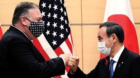Japan's Prime Minister Yoshihide Suga and Secretary of State Mike Pompeo (L) bump fists as they meet at the prime minister's office in Tokyo on Tuesday.