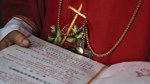 A Chinese Catholic deacon holds a bible at the Palm Sunday Mass during the Easter Holy Week at an "underground" or "unofficial" church on April 9, 2017 near Shijiazhuang, Hebei Province, China. 