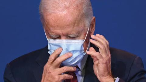 Democratic presidential candidate Joe Biden adjusts his facemask as he speaks on healthcare at The Queen in Wilmington, Delaware, on October 28, 2020. 
