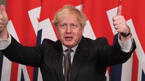 U.K. Prime Minister Boris Johnson celebrates after signing the Brexit trade deal in London, Dec. 30, 2020.