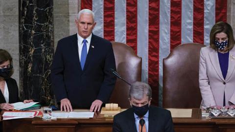 Vice President Mike Pence and Speaker of the House Nancy Pelosi, D-Calif., read the final certification of Electoral College votes cast in November's presidential election during a joint session of Congress, after working through the night, at the Capitol