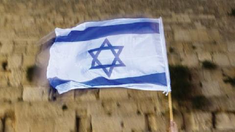 An Israeli waves a flag during a parade marking Jerusalem Day at the Western Wall in 2009.