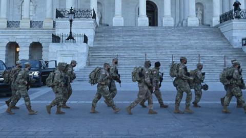 Members of the US National Guard walk outside the US Capitol on January 19, 2021 in Washington, DC