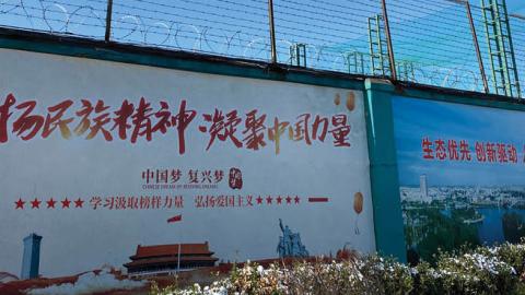 The wall alongside one of the factories in China where Uighur people work and live in dorms.
