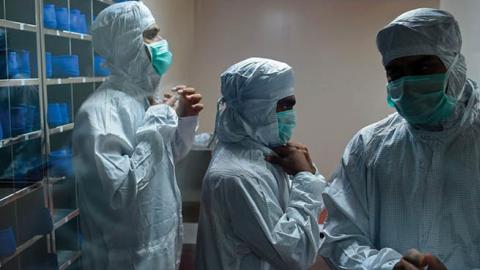 Employees prepare themselves before getting inside a lab where Covishield, AstraZeneca-Oxford's Covid-19 coronavirus vaccine is being manufactured, at India's Serum Institute in Pune on January 22, 2021.