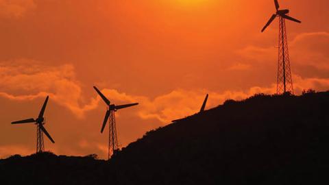 Wind power generators are enveloped in a smoky sky near the Millard fire on July 15, 2006 near Cabazon, California.