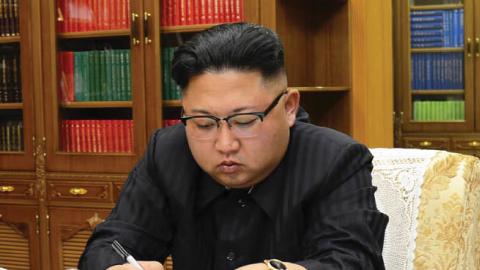 North Korean leader Kim Jong-Un signing the order to carry out the test-fire of the intercontinental ballistic missile Hwasong-14 at an undisclosed location (STR/AFP via Getty Images)