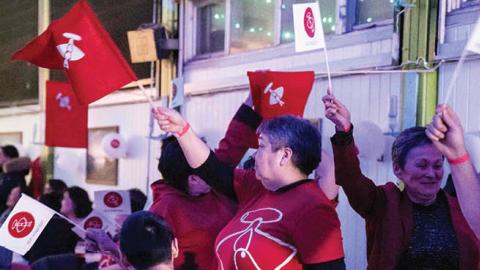 Members of the IA (Inuit Ataqatigiit) party wave party flags as they celebrate following the exit polls results of the legislative election in Nuuk, on April 6, 2021 (Photo by EMIL HELMS/Ritzau Scanpix/AFP via Getty Images)