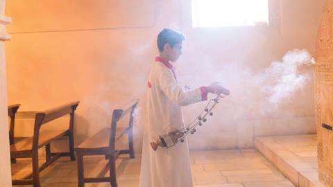 In this photograph taken on February 23, 2020, a young member of the Assyrian Christian community walks with insense during a Sunday mass at the More Benham Kirklar Church in Mardin, south-eastern Turkey (Photo by BULENT KILIC/AFP via Getty Images)