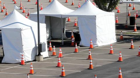 A worker walks at a large scale COVID-19 vaccination site under construction at Cal State Los Angeles on February 12, 2021 in Los Angeles, California (Photo by Mario Tama/Getty Images)