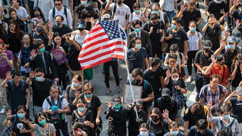 A Protester is seen holding up a US Flag in Hong Kong on September 8, 2019, Protester march from Charter Garden to the US Consulate in Hong Kong calling for support. (Photo by Vernon Yuen via Getty Images)