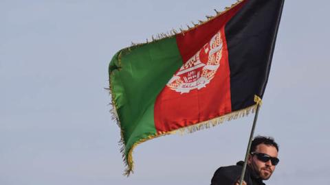 Afghan Commando beneath an Afghan national flag in Shindand Military Base, Herat province (Photo by Franz J. Marty/SOPA Images/LightRocket via Getty Images)
