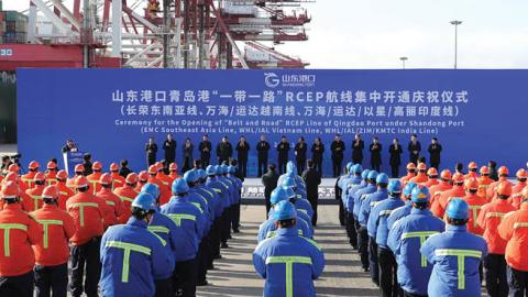 Workers attend the ceremony for the Opening of 'Belt and Road' RCEP Line, including EMC Southeast Asia Line, WHL/IAL Vietnam Line and WHL/IAL/ZIM/KMTC India Line, at Qingdao Port on January 19, 2021 in Qingdao, Shandong Province of China. (Photo by Zhang 